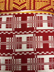 100% Cotton woven kente print fabric in red and white with a gold multipattern border